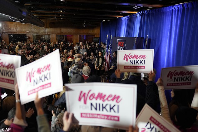 Supporters hold signs reading 