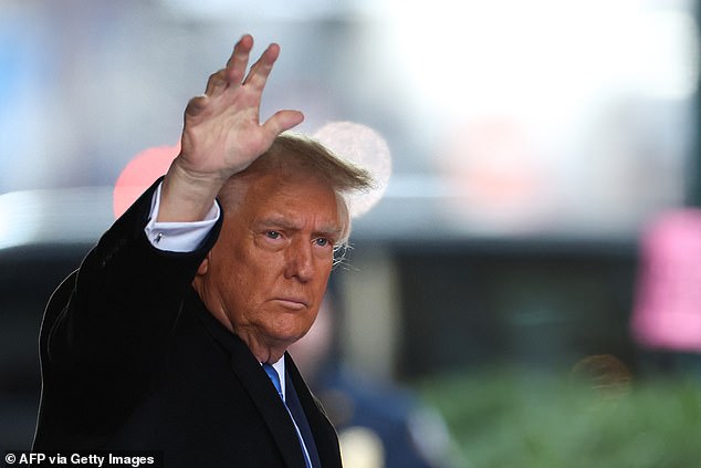 Trump waves to his supporters as he leaves his building in downtown Manhattan on Monday morning to head to his motorcade