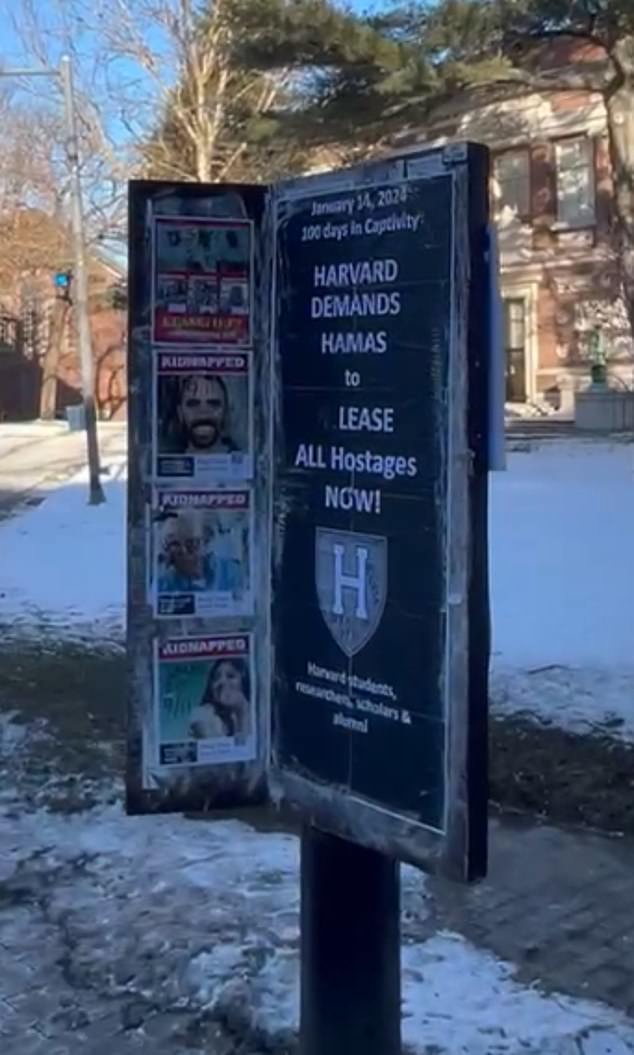 A sign in the center of Harvard Yard features both the defaced posters and a call for the hostages' release