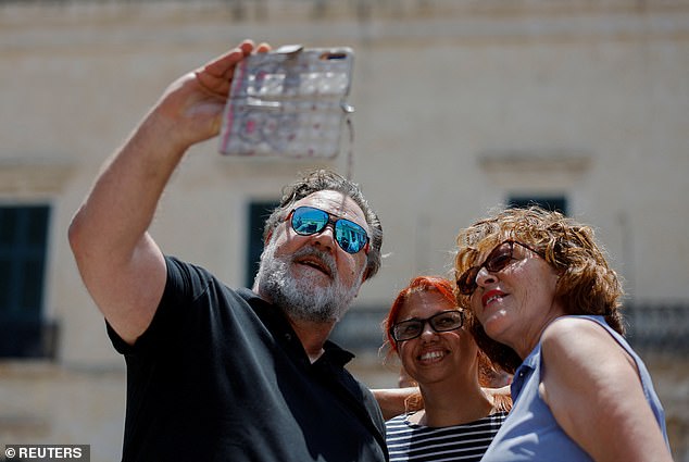 Crowe (pictured) stopped to take selfies with fans outside in the Maltese capital Valletta last June