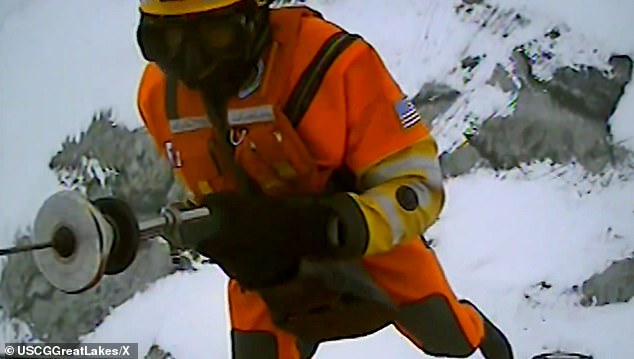 A US Coast Guard rescuer is hoisted onto the ice to save nine people