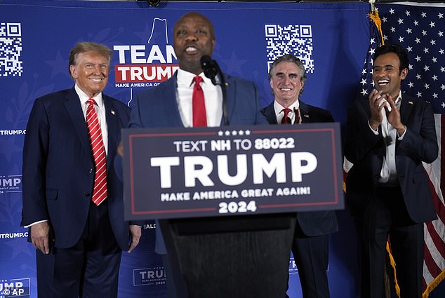 Sen. Tim Scott, R-S.C., speaks as Republican presidential candidate, former President Donald Trump, listens with North Dakota Gov. Doug Burgum and Vivek Ramaswamy listen during a campaign event in Laconia, New Hampshire on Monday evening