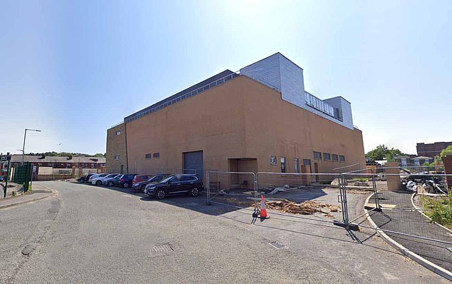 The building, which opens in March, can be seen from the back next to a parking garage