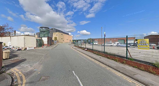 The building can be seen from a distance near a car wash and a landfill