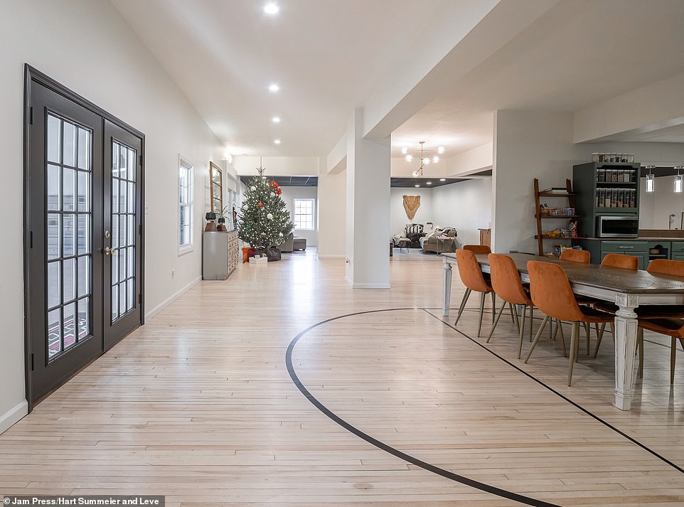 Pictured are elegant French doors leading visitors into the kitchen built on the polished wood floors of the old basketball court