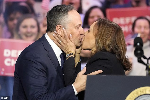 Vice President Kamala Harris kisses her husband, Second Gentleman Doug Emhoff, before President Joe Biden appears at an event on the campus of George Mason University in Manassas, Virginia.