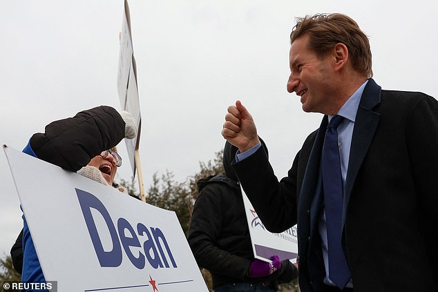 Rep.  Dean Phillips fist bumps a supporter during a stop Tuesday at a polling place in Londonderry, New Hampshire.  Phillips launched his presidential bid in October after months of warning that the 81-year-old Biden would lose to former President Donald Trump