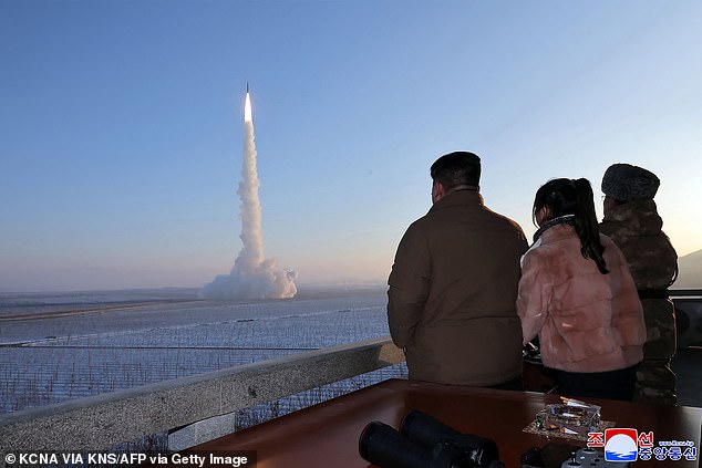 North Korean leader Kim Jong Un (L) and his daughter watch the test launch of a Hwasongpho-18 intercontinental ballistic missile.  The undated photo was released on December 19