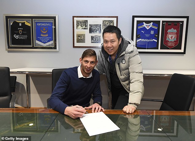 Sala signed for Cardiff in 2019, with CEO Ken Choo holding a silver pen