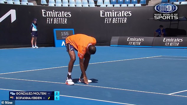 The match was eventually moved to the Margaret Court Arena (photo, Rohan Bopanna identifies problem areas on the pitch)