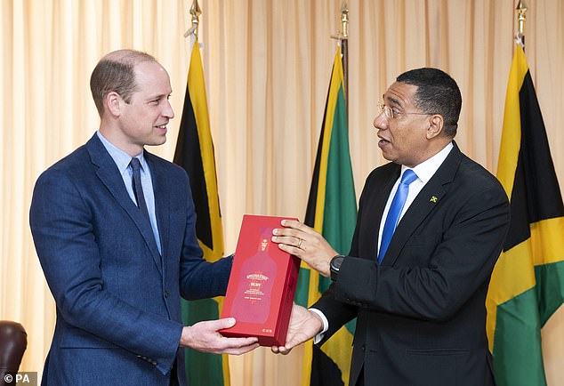 Jamaica's Prime Minister Andrew Holness presents the Duke of Cambridge with a bottle of Appleton Estate Ruby during a meeting at his office in Kingston, Jamaica