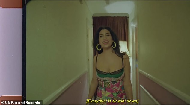 Previously unused images from the set show Winehouse wearing a floral mini dress and understated makeup as he walks the hotel's plush carpets