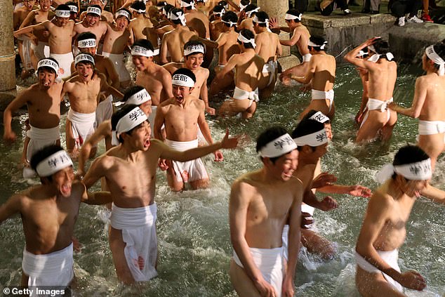 In a 2016 photo, men clean their bodies in a fountain before entering Saidaiji Temple