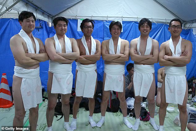 Men pose as they prepare to take part in the ancient festival.  The men wear only bandanas, loincloths and socks