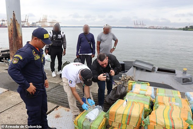 A Colombian official examines some of the cocaine seized after the navy intercepted a narco-submarine on Saturday