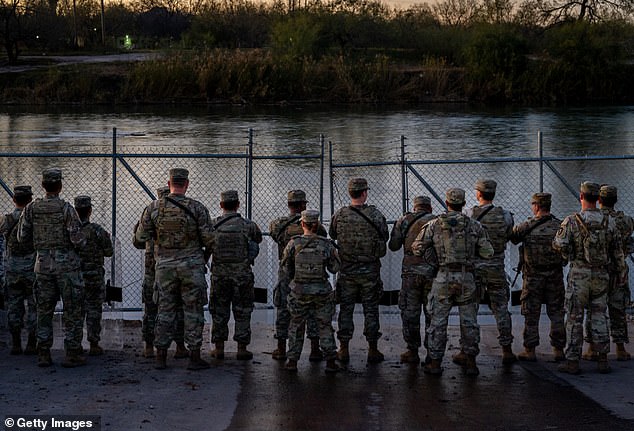 National Guard soldiers stand guard on the banks of the Rio Grande River in Shelby Park