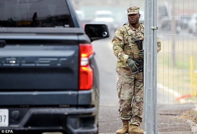 A National Guardsman lets a truck into a gate at Shelby Park in Eagle Pass, Texas.  The Texas Military Department confirmed that the Texas National Guard has taken control of the area