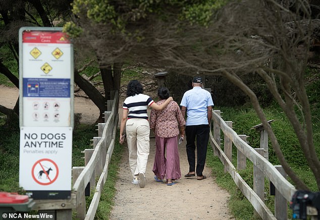 The beach is not patrolled, but there are signs warning swimmers of rough conditions (Photo: Mourners at the scene on Thursday)