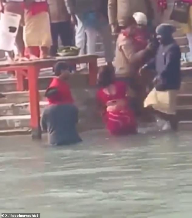 The man in the hat is then seen apparently taking the child away from the desperate family