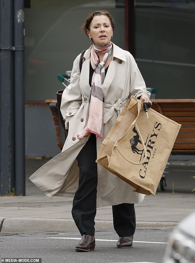 The Young Talent Time star wraps a pink, gray and white striped scarf around her neck and accessorizes with a pair of shiny brown boots