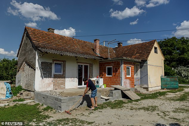 Danijel Harmnicar, owner of a house bought for 1 HRK, works on a garden in the village of Legrad, Croatia, June 10, 2021. In a new attempt to attract new residents, government officials announced in January that a new batch of houses is ready for sale only June 10, 2021. cents