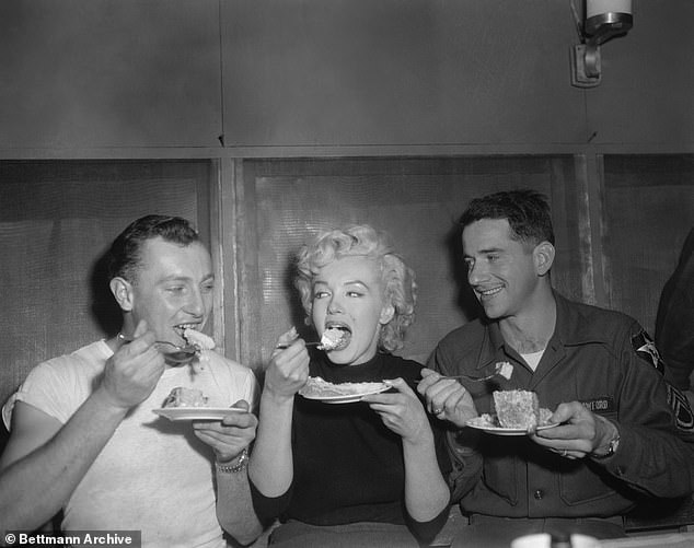 Marilyn tries some cake at the Enlisted Men's Mess Hall of Headquarters Company, 2nd Infantry Division, near Seoul