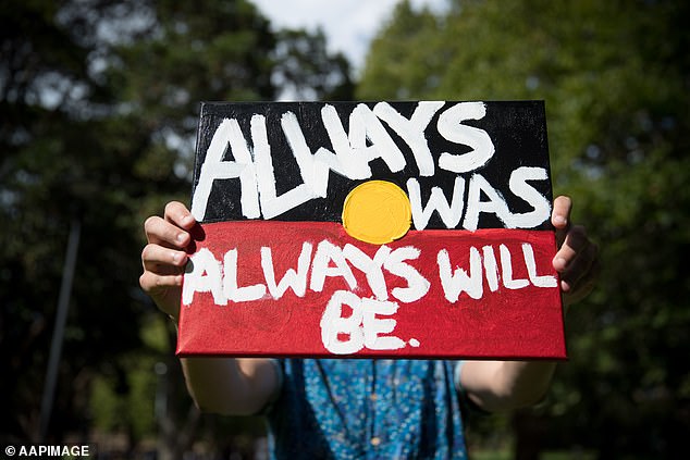 As the colony spread, violence increased and more and more land was seized.  A protester is pictured holding a sign at an Invasion Day rally in Sydney on Friday