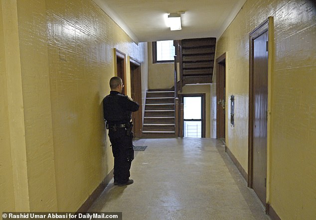 An officer stands guard in the apartment building on Tuesday