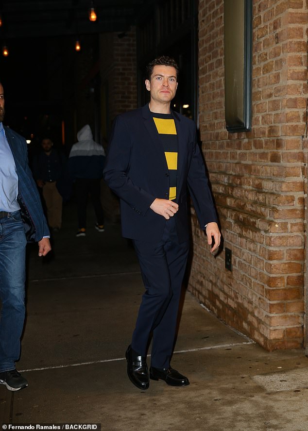 Mann opted for a black and yellow striped shirt under a black jacket, black trousers and shiny black dress shoes