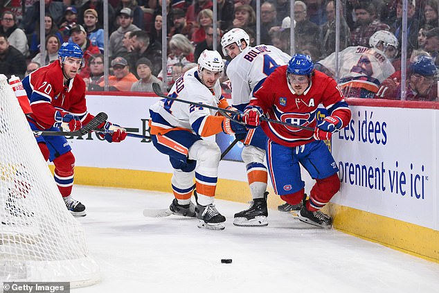 The Islanders' Scott Mayfield and Gallagher skate after the puck during the second period