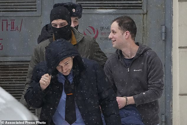 Gershkovich puts on a brave face as he laughs with guards, right, being escorted from the Lefortovsky Court in Moscow, Russia