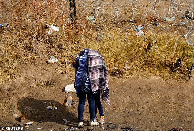 Clara Morales and her daughter Yuridia, migrants from Guatemala seeking asylum in the US, embrace in front of barbed wire set up to hinder the crossing of migrants into the US, seen from Ciudad Juarez, Mexico