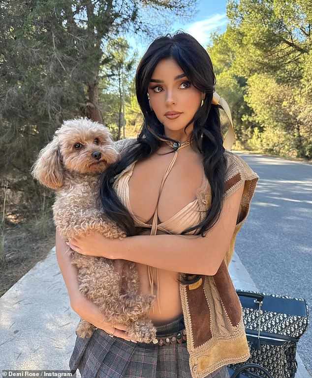 The beauty recently showed off her bountiful assets in a nude bikini top and pleated micro mini skirt as she cuddled her pet Teddy in a sizzling Instagram snap