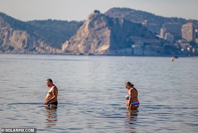 People taking a dip in the Mediterranean Sea while enjoying the sunny weather in Benidorm