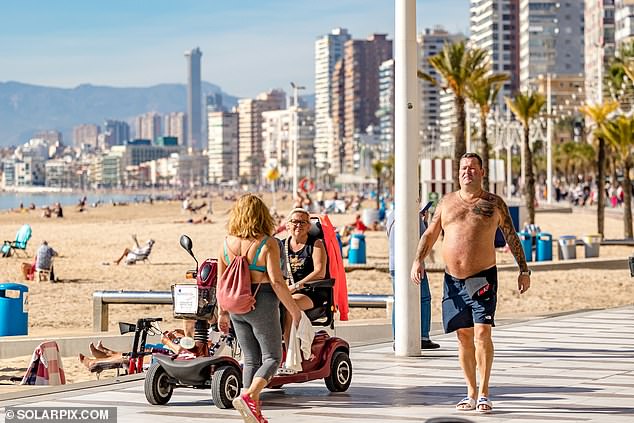 It's a good day for a walk on the boulevard, these beachgoers in Benidorm seem to think