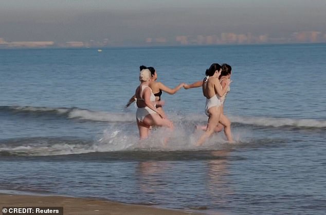 A group of women running into the sea during Spain's unusually warm temperatures