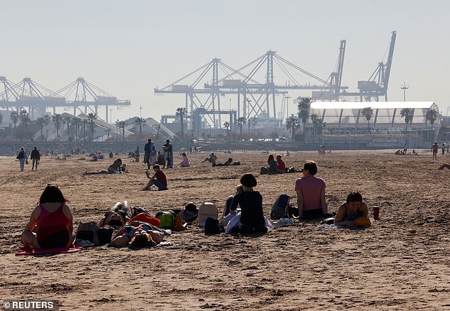 People enjoy the sun on Thursday at Malvarrosa beach in Valencia, Spain