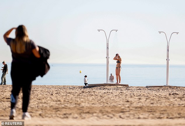 A woman showering in a swimsuit in Valencia, Spain on Thursday