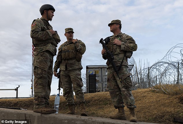 Texas National Guard soldiers wait near the boat ramp where law enforcement enters the Rio Grande in Shelby Park on January 26, 2024