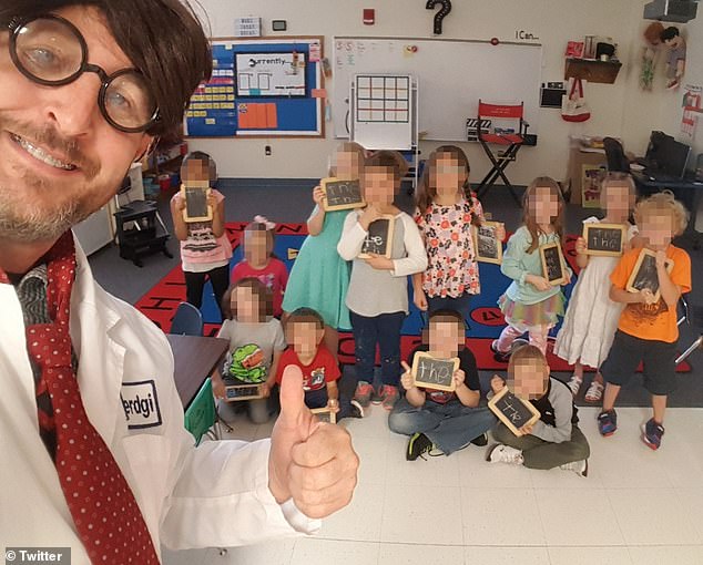 Stultz stands dressed up in a costume in his classroom with his students nearby