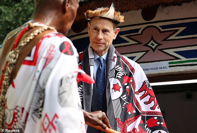 Prince Edward, Duke of Edinburgh receives a gift from a traditional healer during a tour of the Pretoria National Botanical Garden in Pretoria, South Africa