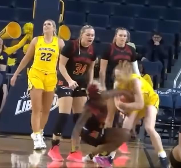 Maryland's Bri McDaniel is seen on the ground trying to grab the ball from Michigan's Lauren Hansen