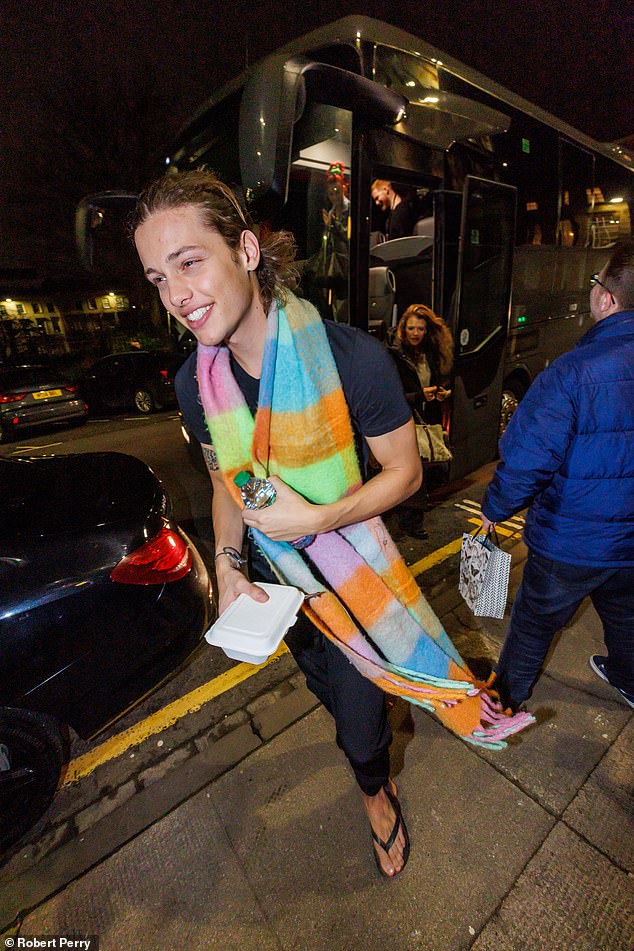 Bobby appeared cheerful as he went to the hotel in Ellie's scarf