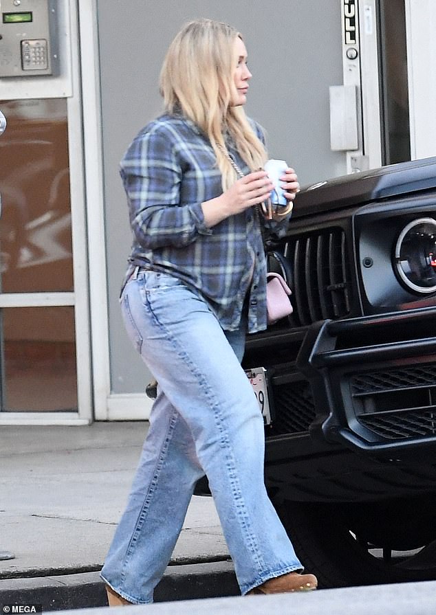 Hilary paired the look with low-rise jeans and brown suede heeled boots.  She carried a pink crossbody bag and wore her long blonde hair in a center parting