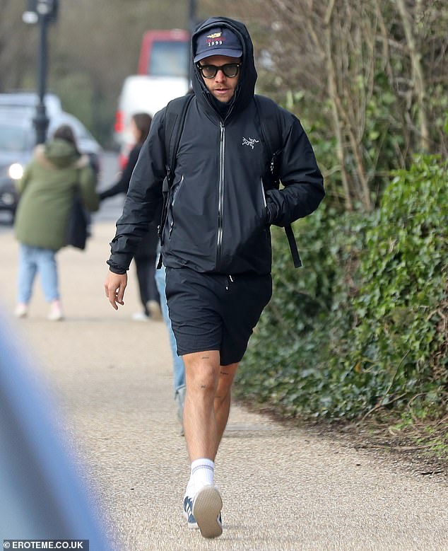 The singer paired his dark blue shorts with a matching jacket and cap and dark sunglasses.  He kept his hood up and completed his look with white socks and sneakers