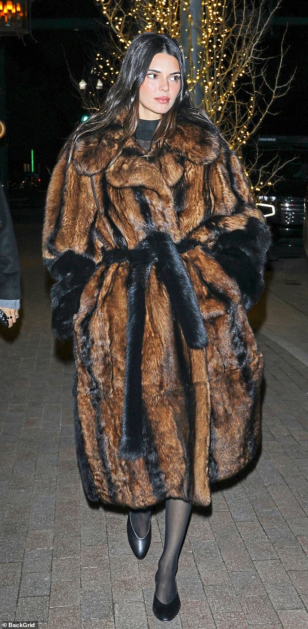 Model Kendall Jenner, 28, shows off three real and faux fur coats, including a black and brown striped Phoebe Philo coat, which cost a whopping £21,000