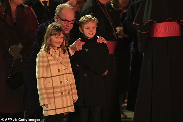 A touching moment was caught on camera as Prince Albert crouched down to talk to his young children, whose beaming faces were lit up by the brightness emanating from the flames.