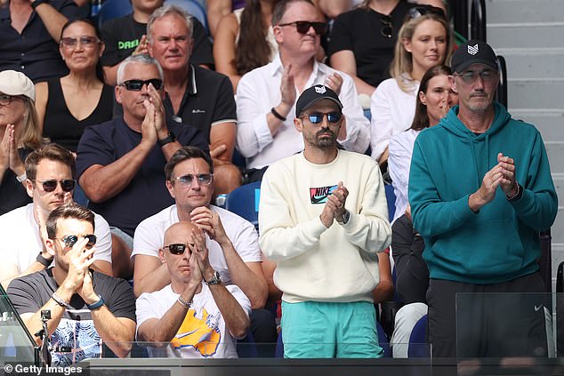 Pictured: Cahill (right) standing and applauding in Sinner's box during his victory over Djokovic