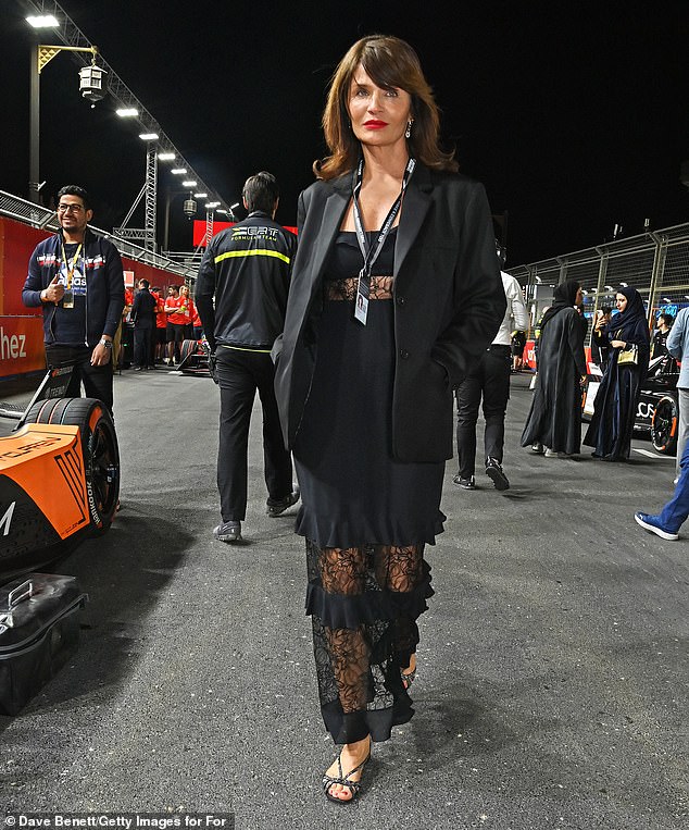 The beauty wore a bold red lipstick and teamed her outfit with glitzy silver and black sandals as she braved a storm during the race