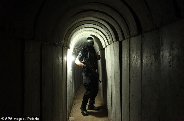 A member of the Ezzedine al-Qassam Brigades, the military wing of the Palestinian Islamist movement Hamas, walks into a tunnel used for military exercises during a weapons exhibition at a Hamas-run summer camp for youth in Gaza City.